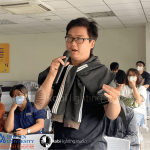 A confident apprentice presenting ideas to an engaged audience.