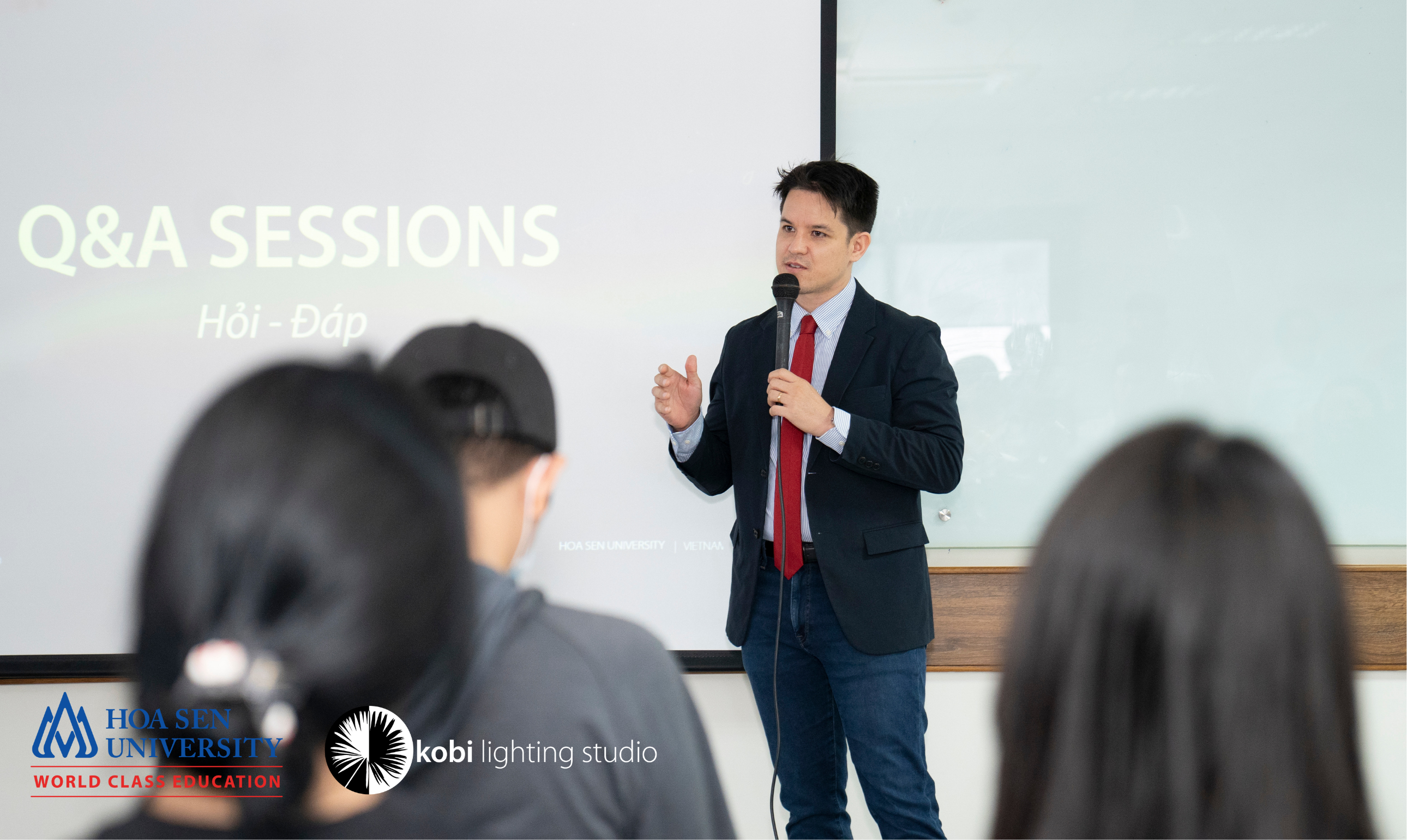 A professional standing in front, passionately undertaking Q&A session on Human-Centric-Lighting with students.
