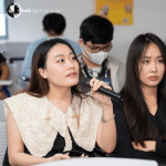 a student sitting calmly inquiring about the subject lectured to her group.