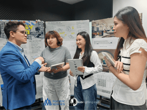 Mr. Jonathan discusses with Doan Trang, Ngoc Thao, and Thanh Van after their pre-elementary presentation